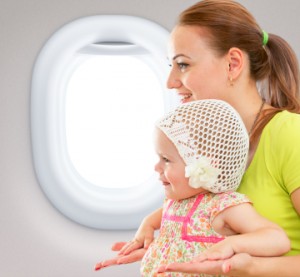 Happy mother and child sitting together in airplane cabin near w